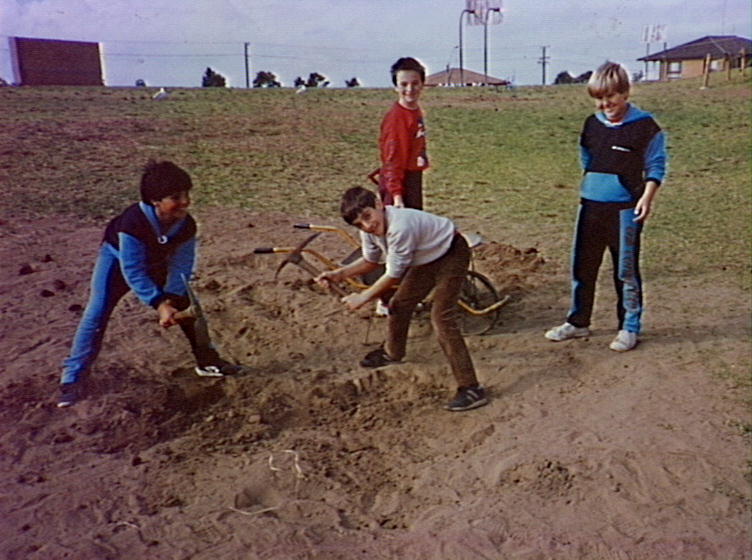 Pupils digging holes for trees at Barrack Heights Public School