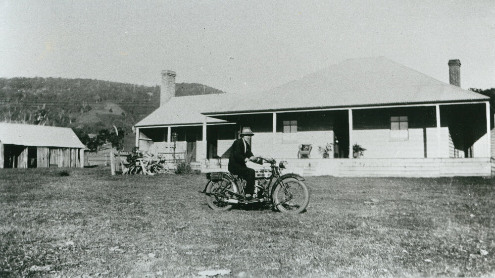 Harold Smith on a motorbike at 'Wattle Grove', Albion Park