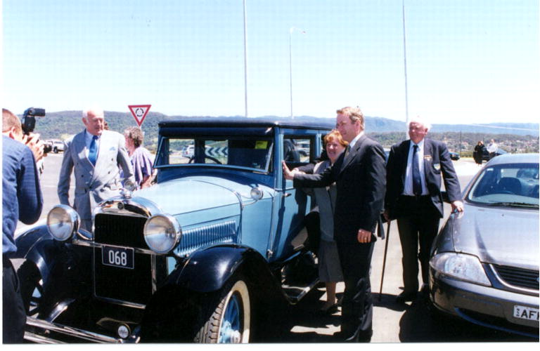 Vintage car and officials at the opening of Oak Flats Interchange